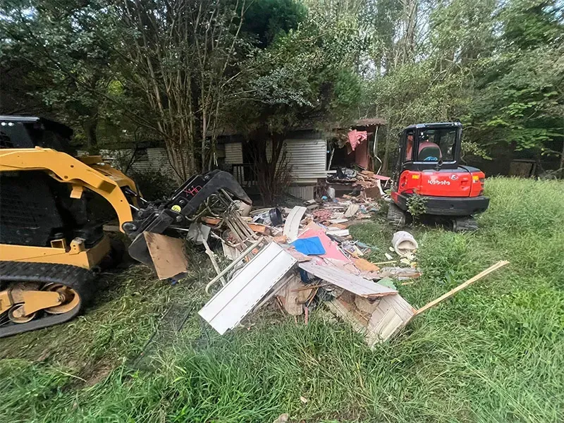 Mobile home cleanout with excavator removing debris